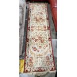 Large cream ground runner with several floral medallions flanked by floral border 304cm X 99cm