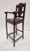 Antique oak child's high chair with foliate carved top rail and backsplat, brown leather seat