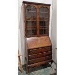 20th century walnut bureau/bookcase, the moulded cornice above two astragal-glazed doors enclosing