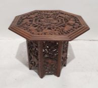Eastern carved table, the octagonal top with carved and pierced elephant and floral decoration. on