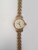 Lady's Longines wristwatch with gold coloured case, baton numerals and side button and the 9ct