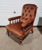 19th century armchair with brown upholstered back, seat and armrests, on turned front legs to