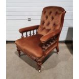 19th century armchair with brown upholstered back, seat and armrests, on turned front legs to