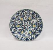 Middle Eastern glazed earthenware charger with stylised flowerhead decoration on a blue-ground, 40cm