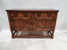 20th century oak sideboard with two drawers above two linenfold decorated cupboard doors, on