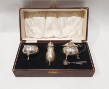 Silver three-piece cruet, all with serpentine rim and blue glass liner, Birmingham 1931, cased