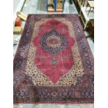 Persian-style carpet having shaped oval floral central medallion to the maroon ground, cream