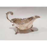 Silver sauceboat with serpentine everted rim, free C-scroll handle, shell and step pad feet,