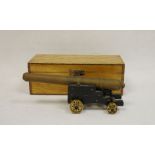 Brass model of a cannon on wooden base with brass wheels, housed in oak case, the barrel approx.