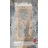 20th century Chinese green ground super wash rug 138 x 71 cm