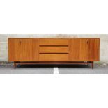 Mid century modern teak sideboard with three central drawers flanked by folding cupboard doors, on