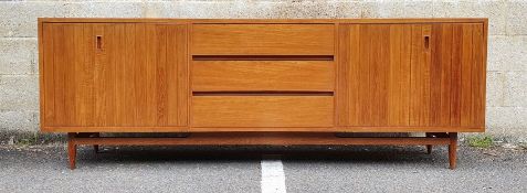 Mid century modern teak sideboard with three central drawers flanked by folding cupboard doors, on