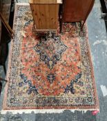 Large red ground rug with central floral medallion surrounded by floral decoration with floral