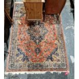 Large red ground rug with central floral medallion surrounded by floral decoration with floral