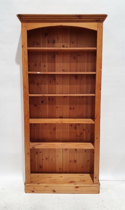20th century pine open bookcase with moulded cornice above assorted shelves, on plinth base, 197.5cm