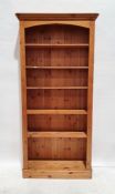 20th century pine open bookcase with moulded cornice above assorted shelves, on plinth base, 197.5cm