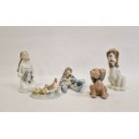 Nao girl kneeling with puppy, Lladro figure group, boy reclining on cushion with dog and puppies,