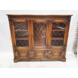 20th century oak cabinet, the moulded carved cornice above three leaded glazed doors enclosing