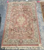 Pink ground rug with central floral pattern surrounded by floral decoration with floral border 172cm