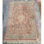 Pink ground rug with central floral pattern surrounded by floral decoration with floral border 172cm