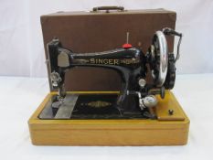 Singer sewing machine in wooden dome box with contemporary user manuals and extra parts including