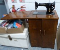 Singer sewing machine, model no.EG579904, housed within a wooden work cabinet