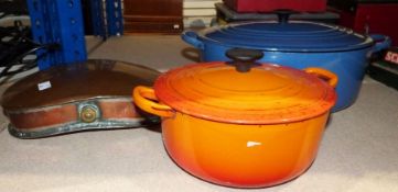 Two Le Creuset cast iron enamelled lidded casserole dishes and a copper warming bottle inscribed '