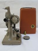 Revere model 85 8mm projector in beige with orange cover, carrying handle and a quantity of 8mm