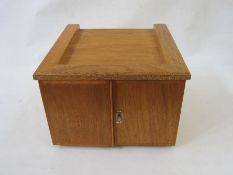 Stained wood table top coin cabinet of 12 drawers enclosed by two doors (three drawers missing),