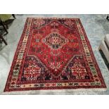 Afghan style red ground rug with blue and ivory lozenge shaped medallion to centre and similar