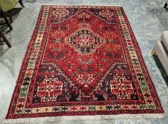 Afghan style red ground rug with blue and ivory lozenge shaped medallion to centre and similar