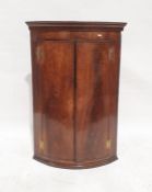 19th century mahogany bowfront wall-hanging corner cupboard, the moulded cornice above two doors