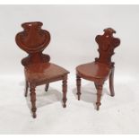 Two mahogany hall chairs with carved shaped seats and turned front legs (2)