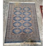 Modern Eastern wool rug with five rows of two octagonal guls in grey-green and beige geometric