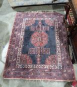 Eastern style red ground rug with central geometric medallion and multiple geometric borders