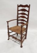Oak ladderback rush-seated chair on turned legs to pad feet, turned stretcher