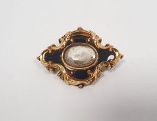 Victorian gold and black enamel memorial brooch, lozenge-shaped and scroll embossed, centred by hair