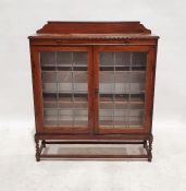 Early 20th century oak bookcase with leaded glazed doors enclosing shelves, on barleytwist