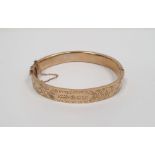 9ct gold bangle with engraved decoration, 12.5g approx. (several dents)