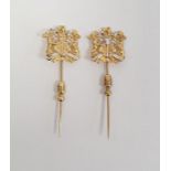 Pair of identical 18ct yellow and white gold hat/tie pins, bearing a coat of arms, stamped 750, 7.7g