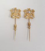 Pair of identical 18ct yellow and white gold hat/tie pins, bearing a coat of arms, stamped 750, 7.7g
