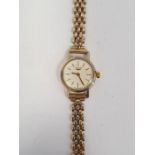 Lady's Longines wristwatch with gold coloured case, baton numerals and side button and the 9ct