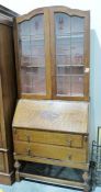 Early 20th century oak bureau/bookcase, the leaded glazed doors enclosing shelves above two drawers,