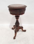 Victorian walnut teapoy of circular form with carved and moulded edge, lift-up top with turned and