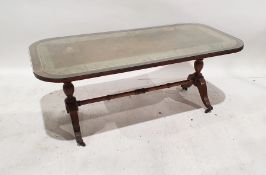 20th century mahogany and leather-topped coffee table on turned end supports to ogee legs,