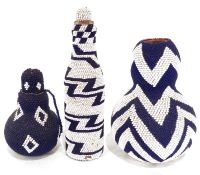 Two African beaded gourds and beaded bottle, featuring blue and white zig-zag and diamond patterns.