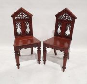 Pair of 19th century mahogany hall chairs with architectural top rail, fretwork carved panels,