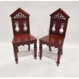 Pair of 19th century mahogany hall chairs with architectural top rail, fretwork carved panels,