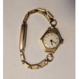 Lady’s gold wristwatch with white enamel circular dial, Arabic numerals, within hexagonal case and