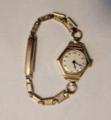 Lady’s gold wristwatch with white enamel circular dial, Arabic numerals, within hexagonal case and